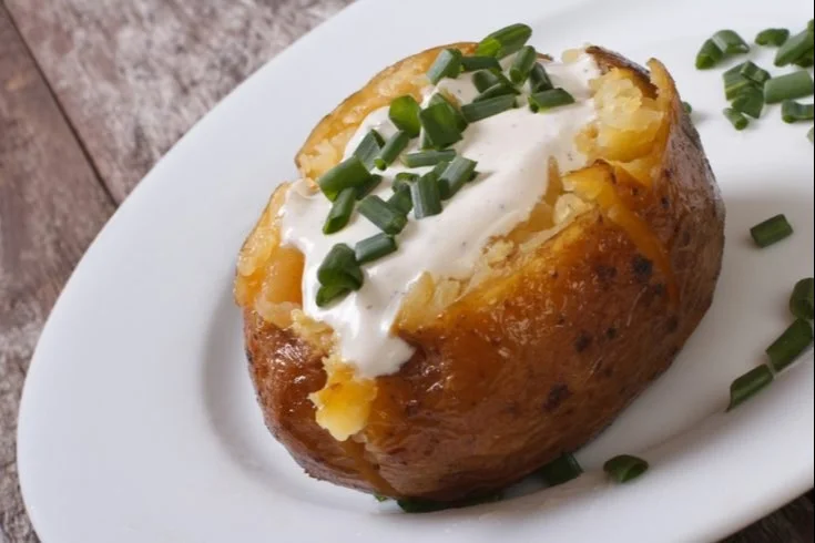 Air fryer baked potatoes ready to be served with toppings.